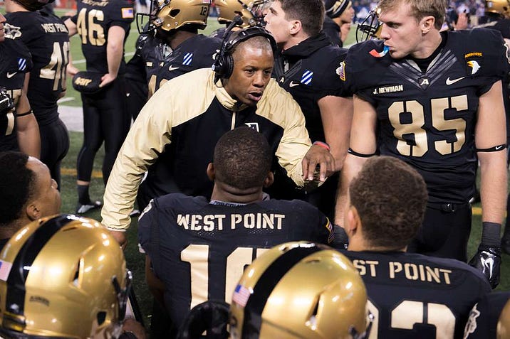 Coach discussing tactics with team.